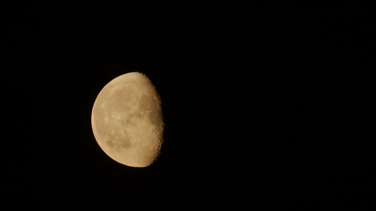 不完整的月亮缓慢地穿过夜空。视频素材