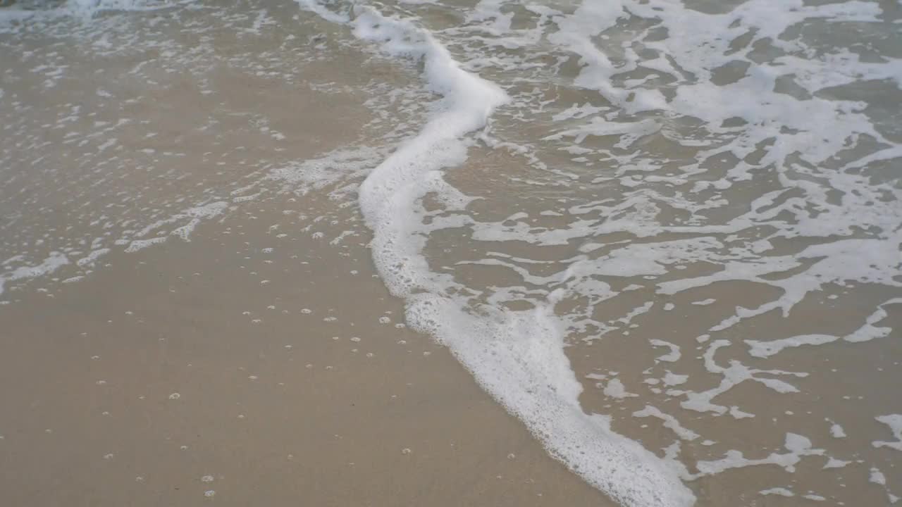 在多云的日子里，海浪拍打着沙滩视频素材