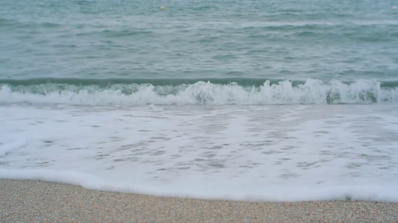 在多云的日子里，海浪拍打着沙滩视频素材