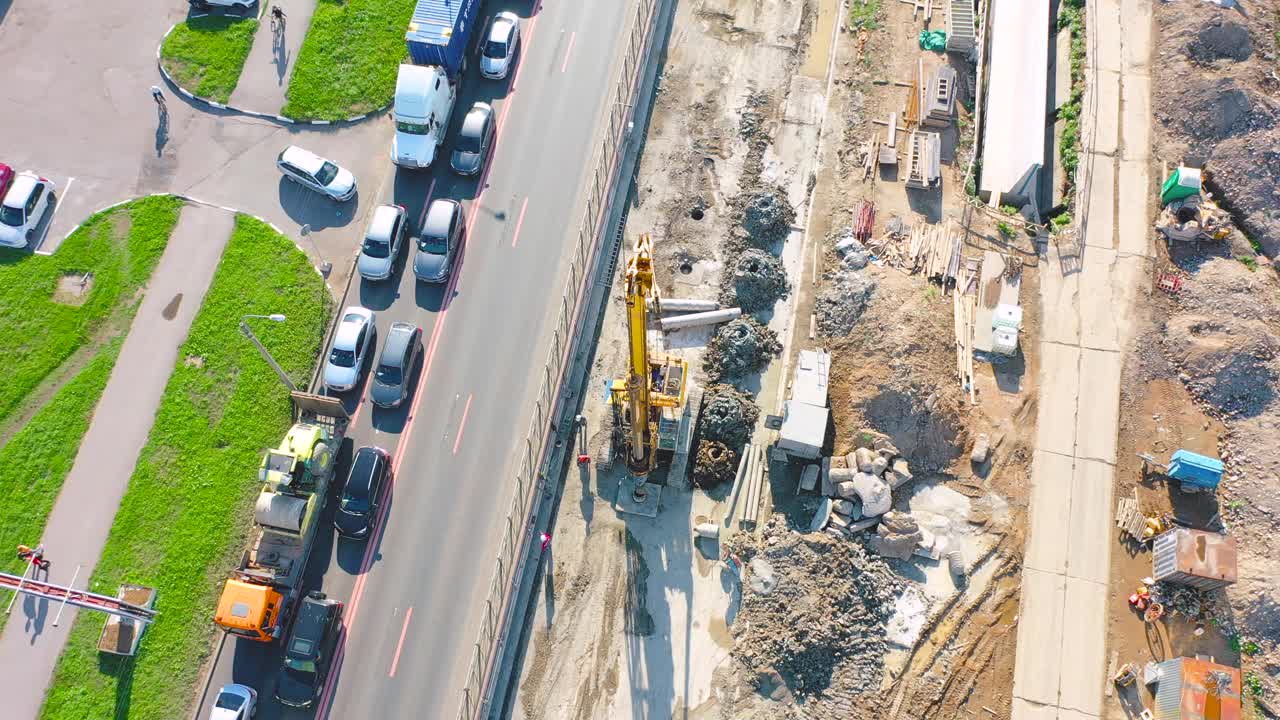 建设城市街道道路交叉口、钻孔、安装桩基、铺设通讯、下水道人孔、排水沟、改善街道路缘、后铺设沥青。准备铺平道路视频素材