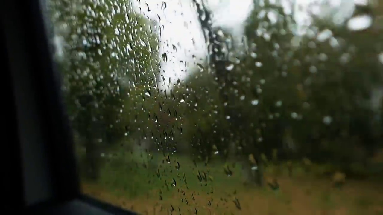 下雨天，乘客POV从车的侧窗往外看视频素材