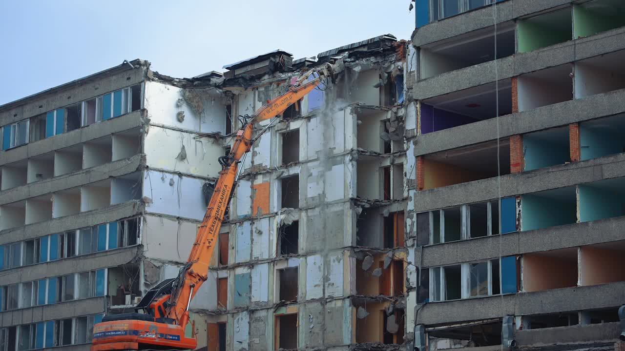 拆除旧住宅楼宇。在施工现场用推土机机械臂拆除旧混凝土建筑。视频素材