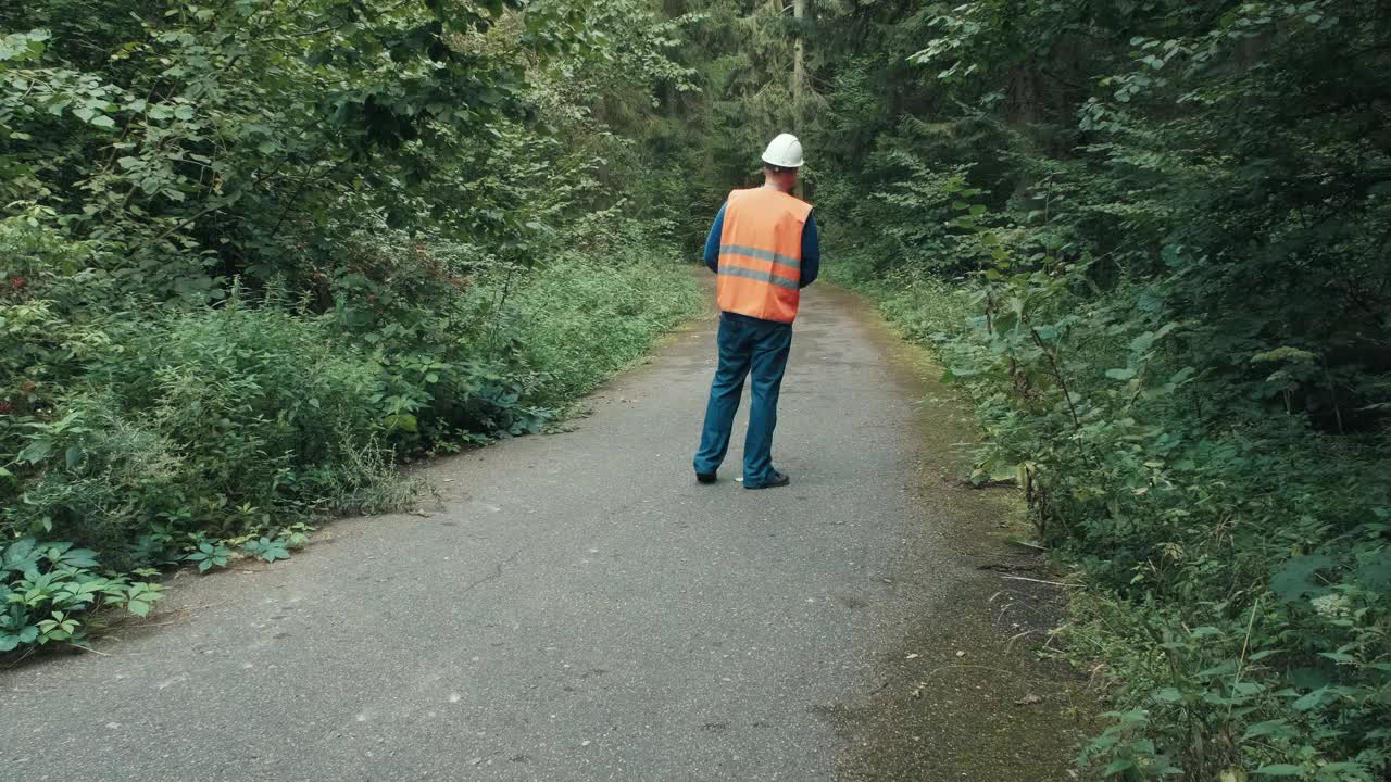 在森林中的高速公路上，穿着工作服戴着头盔的工人视频素材