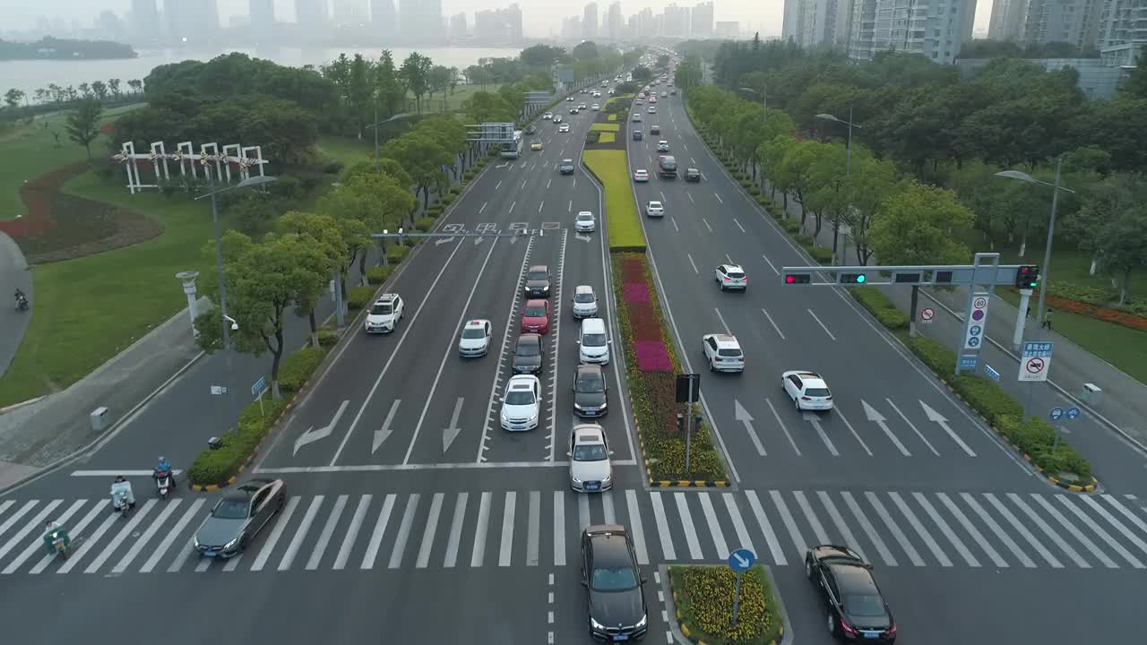 鸟瞰图的汽车运行在城市道路上的日落，中国。视频素材