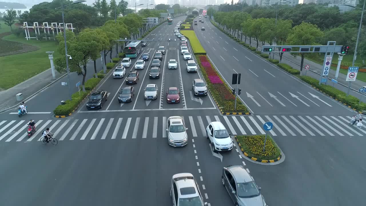 鸟瞰图的汽车运行在城市道路上的日落，中国。视频素材