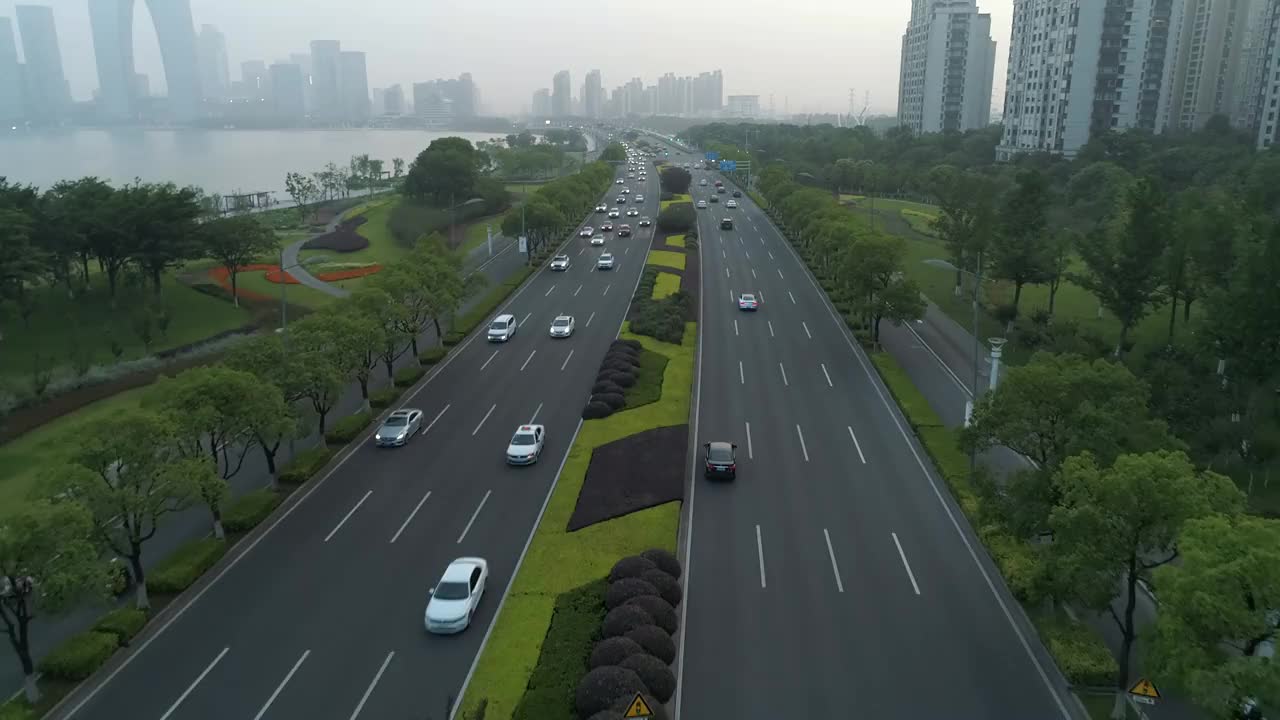 鸟瞰图的汽车运行在城市道路上的日落，中国。视频素材