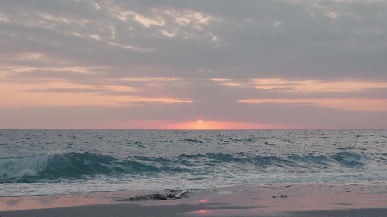 海上日落。阳光反射在水面上。粉红色美丽的日落在暴风雨的海上，时间流逝。美丽的自然景观和多云的天空在黄昏视频素材