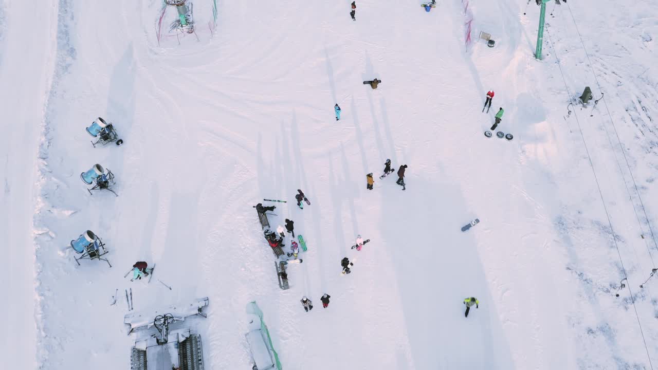 滑雪者和滑雪板运动员使用滑雪缆车在雪坡上滑行。视频素材