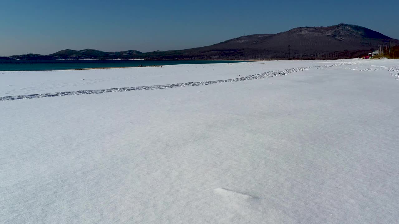 这是覆盖着白雪的海滩的海岸线的鸟瞰图。视频素材