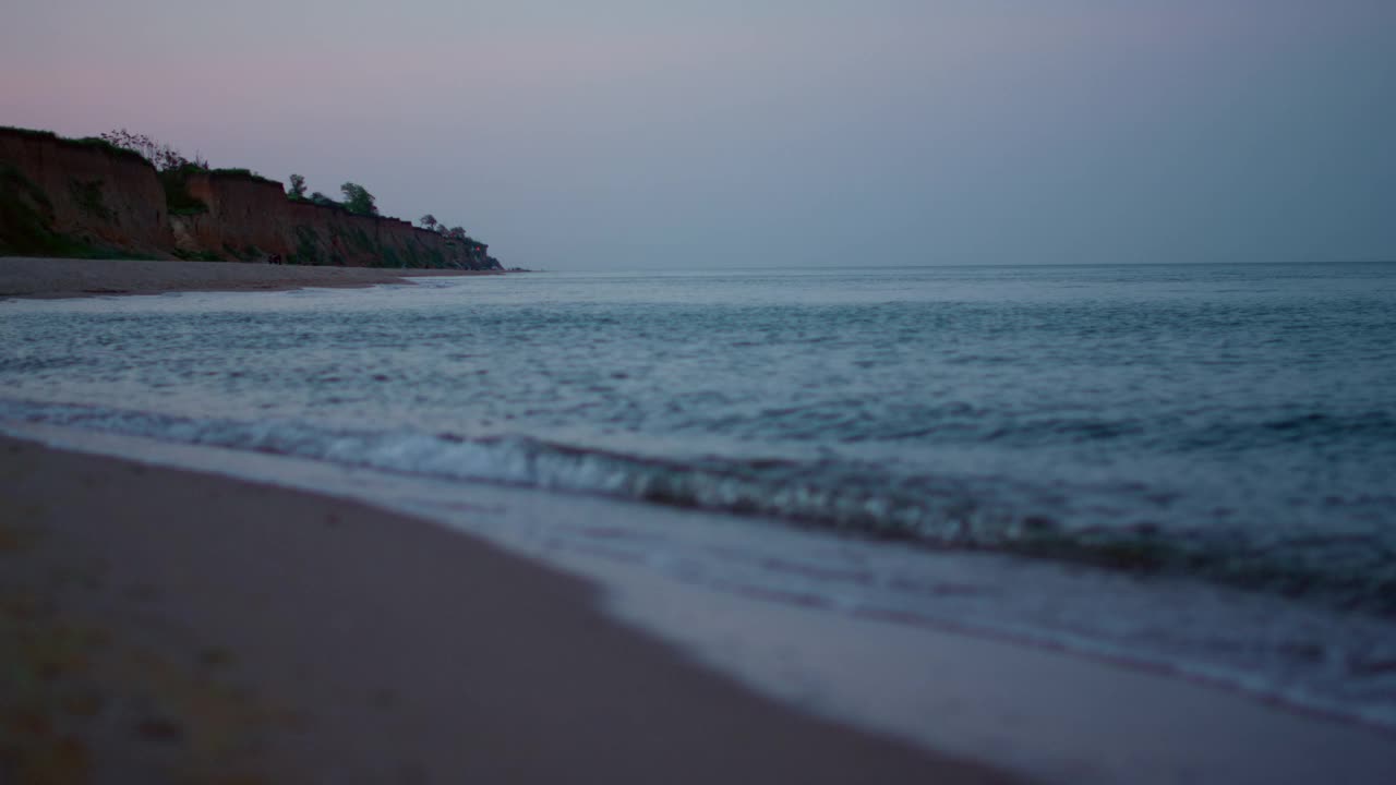 宁静的早晨沙滩海景在寒冷的傍晚日落。蓝色的海水视频素材