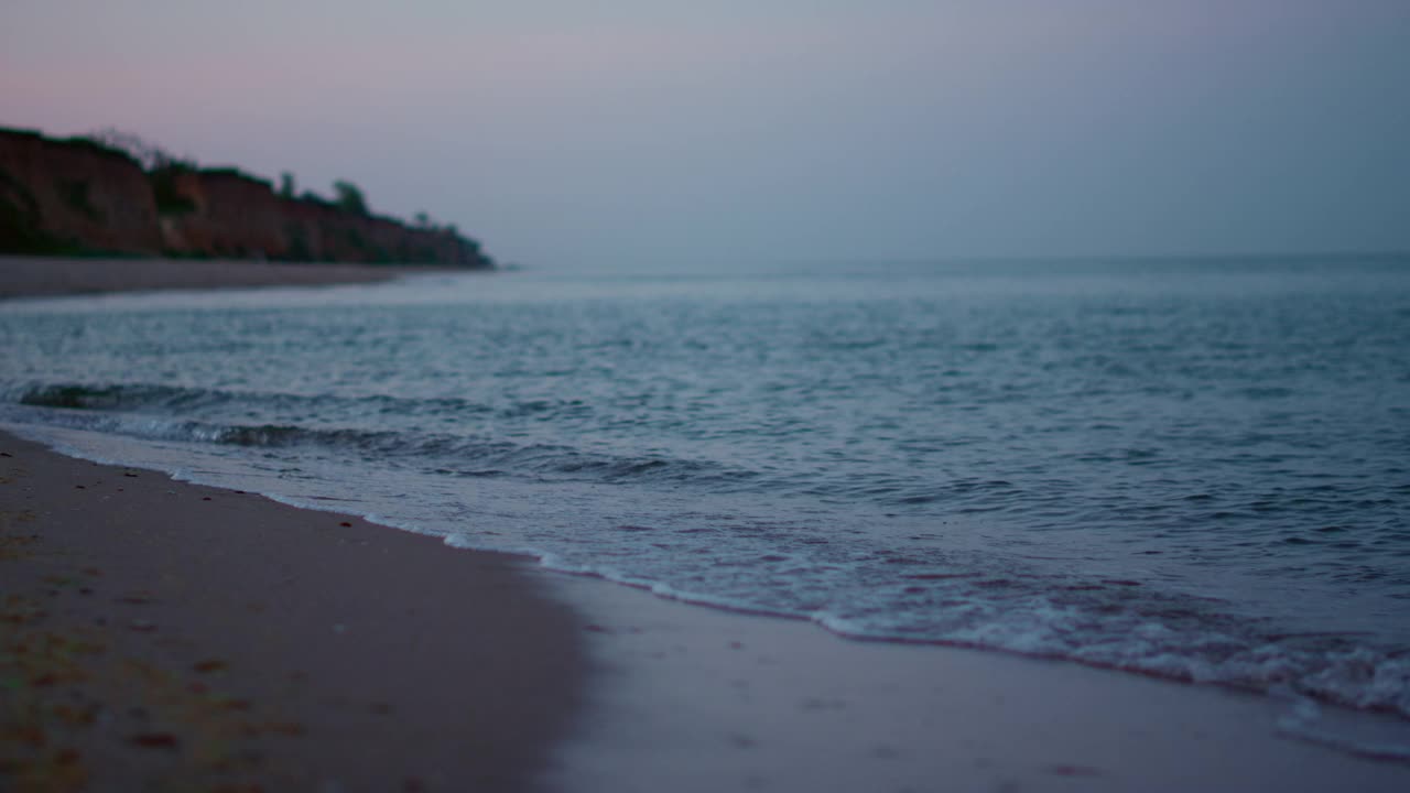 全景，海浪拍打沙滩海滩海岸线在寒冷的天气日出视频素材