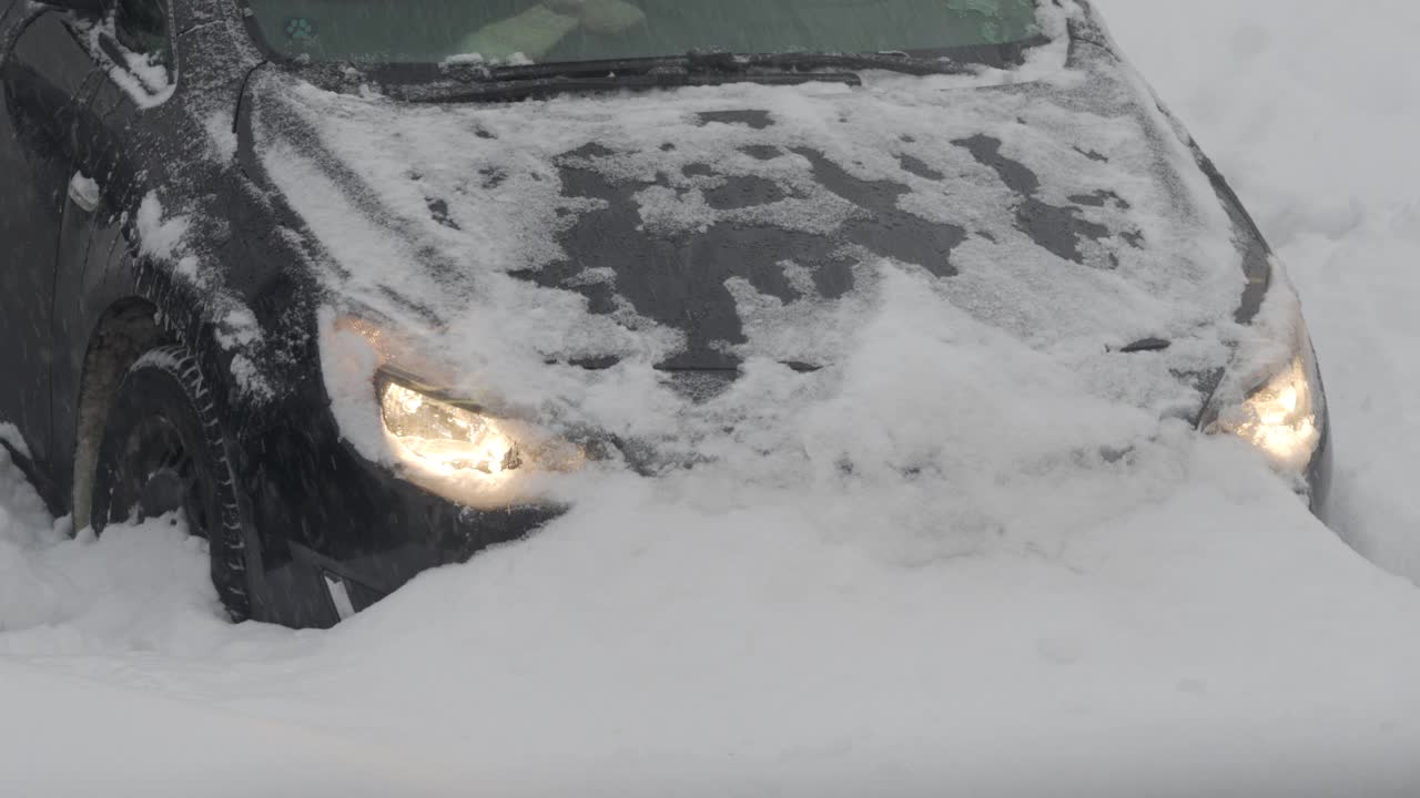 汽车在被雪覆盖的停车场卡在了雪堆里，冬天的暴风雪。视频素材