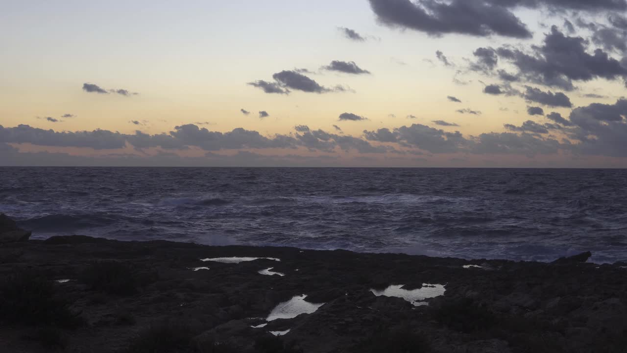 马略卡岛的岩石海岸上，秋天有风的日落，地中海的海浪。崇高的景观视频素材