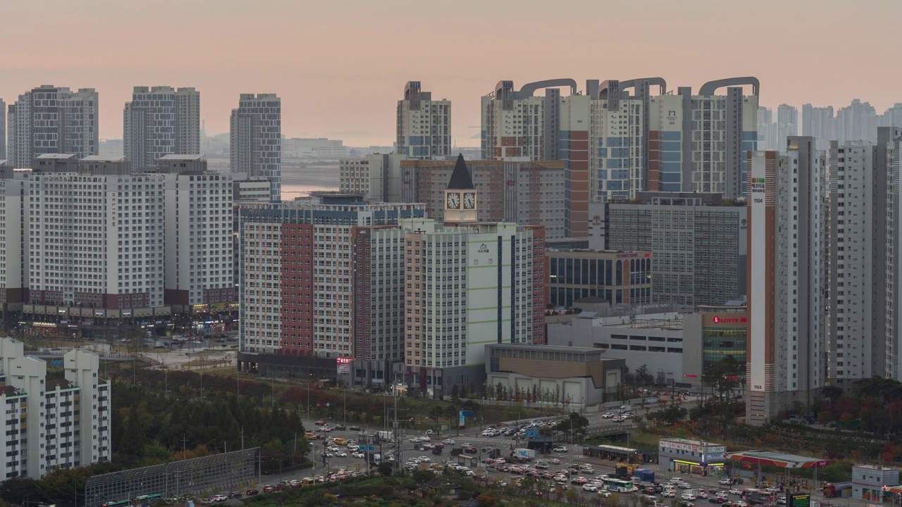 夜晚——韩国京畿道始兴市培歌新城市的公寓大楼和威尼斯广场购物中心的钟楼上的日落视频素材