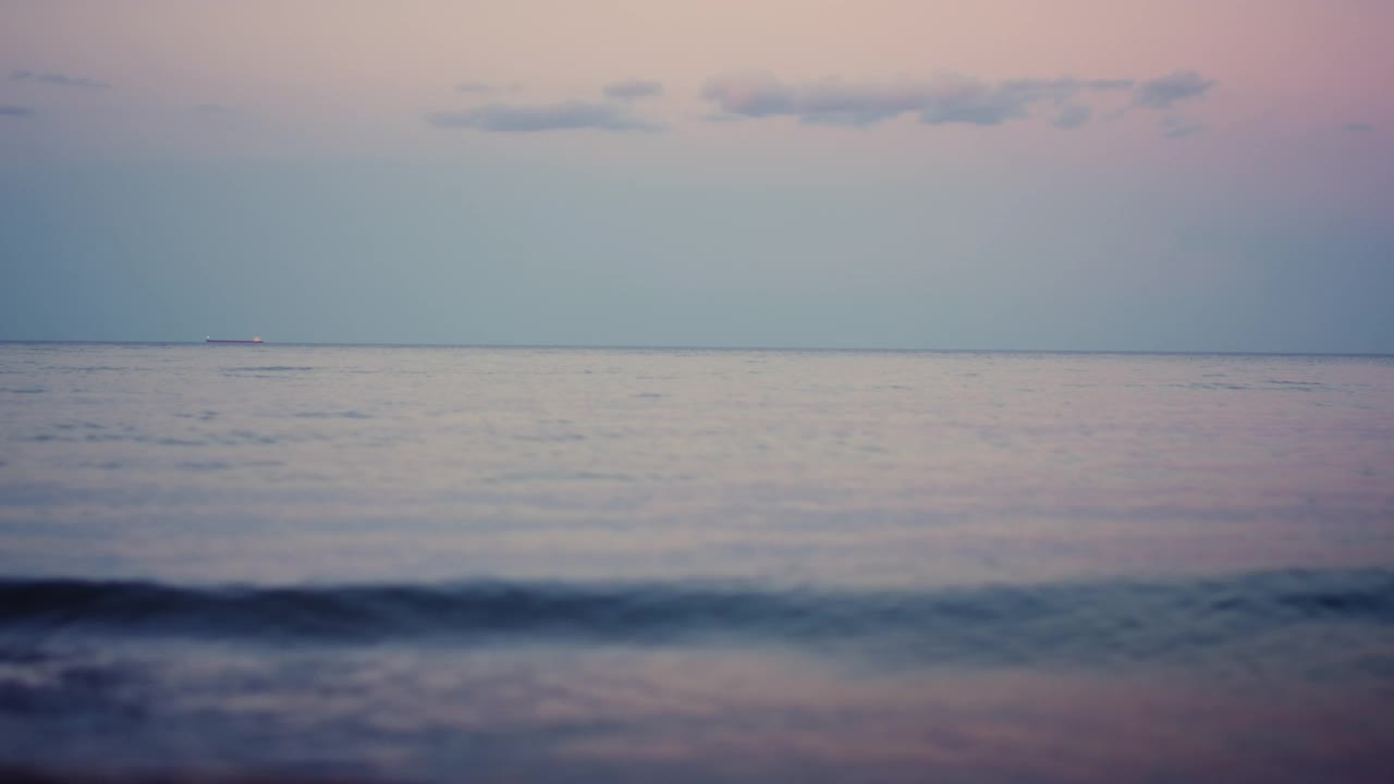 平静的海面地平线在粉红色的天空在寒冷的晨曦。海水波浪视频素材