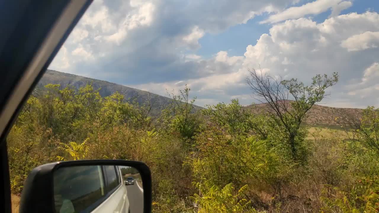 汽车旅行的概念，北马其顿山脉在侧面窗口视频素材