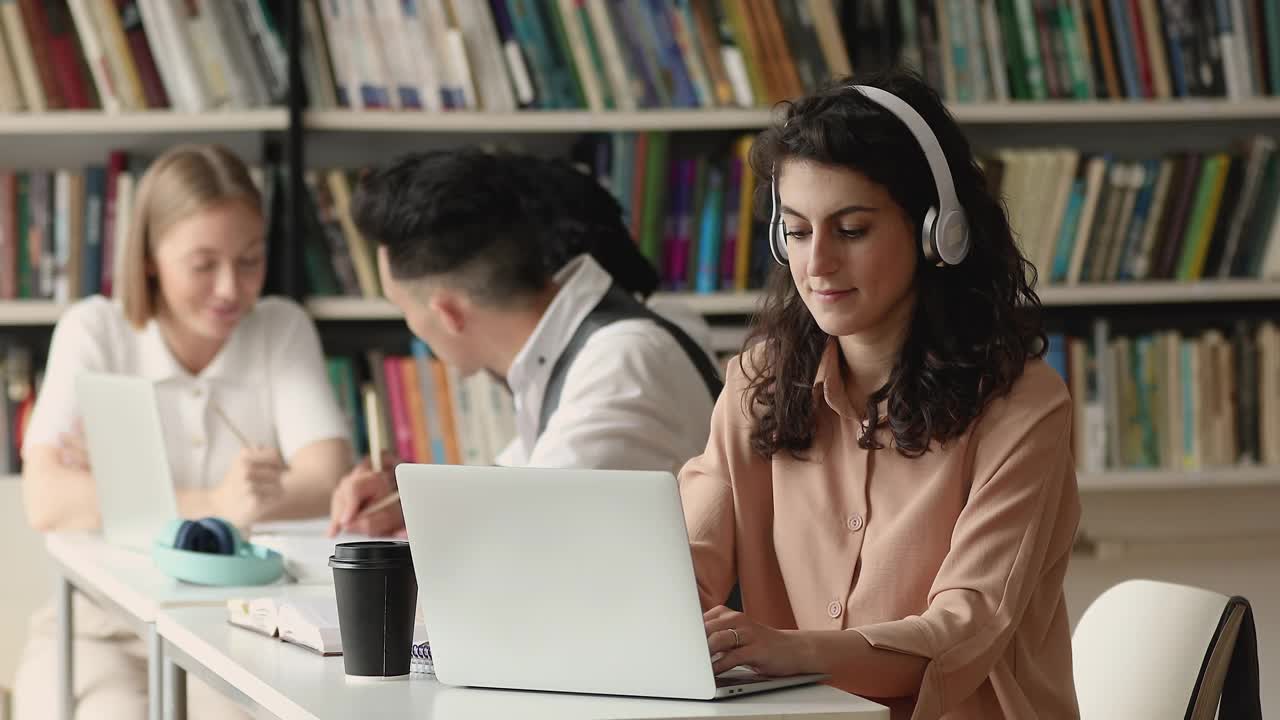 女学生坐在桌旁用电脑准备考试视频素材