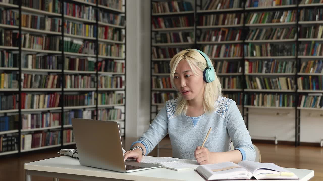 一个女生用笔记本电脑和正在网上学习的老师聊天视频素材