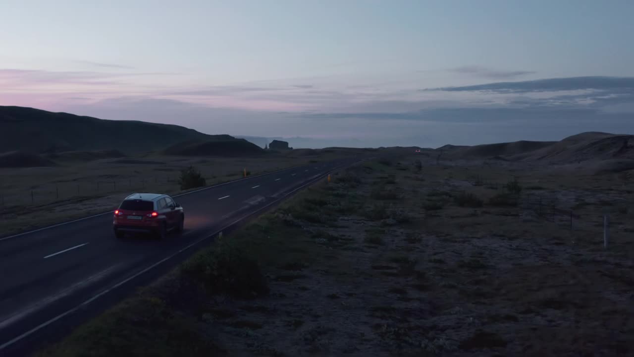 鸟瞰图汽车行驶在空旷的乡村公路在日落。鸟瞰汽车快速行驶在环城公路，冰岛最重要的高速公路视频素材