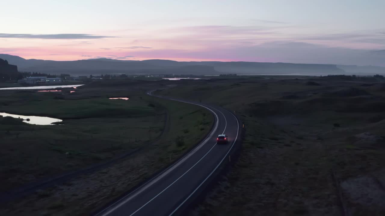 无人机的高速公路汽车和平驾驶在晚上。鸟瞰图在冰岛环城公路与快速驾驶的汽车在日落视频素材