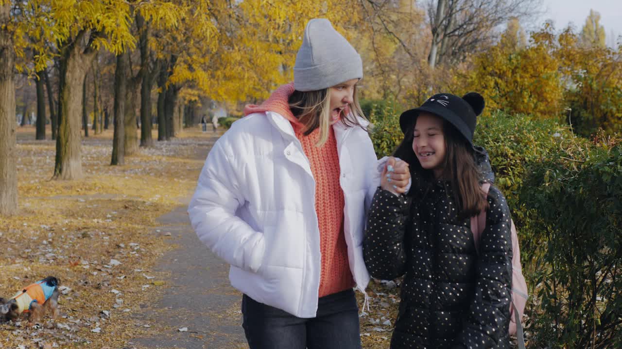 放学后回家。两个女孩将在秋天一起离开学校。视频素材