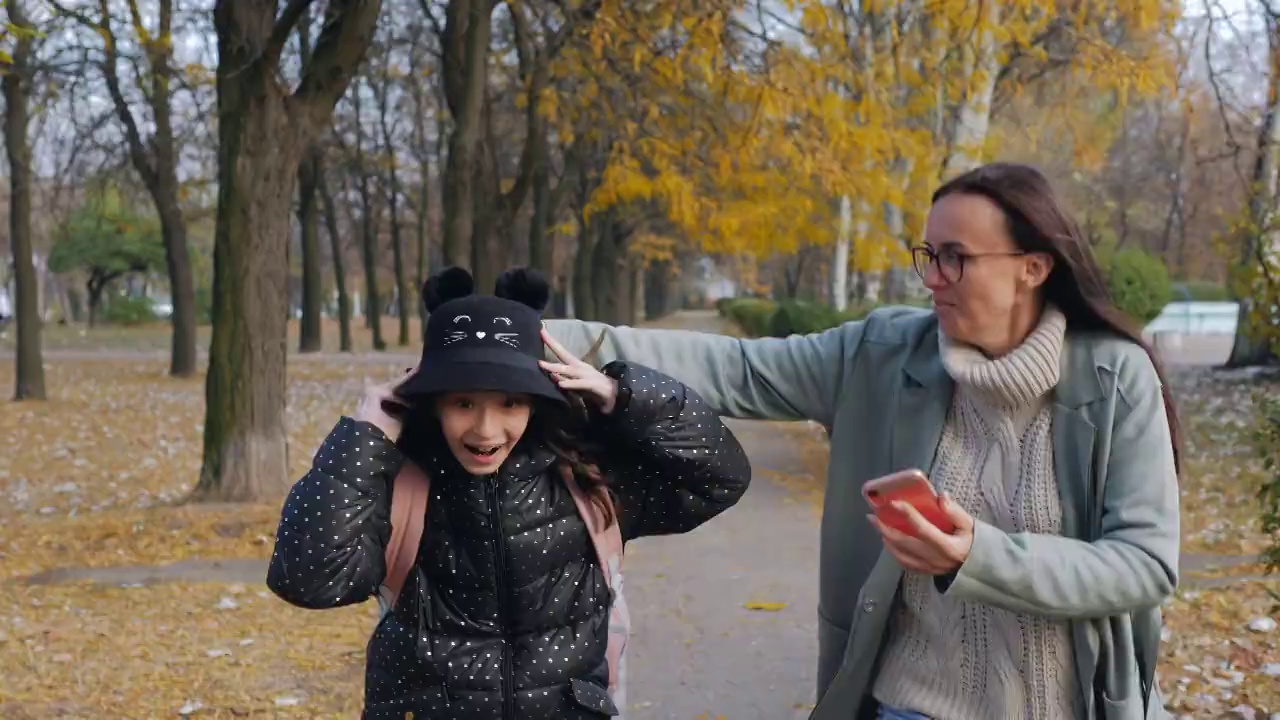 一名小学生的母亲和女儿一起跑去上学，第一节课迟到了。视频素材