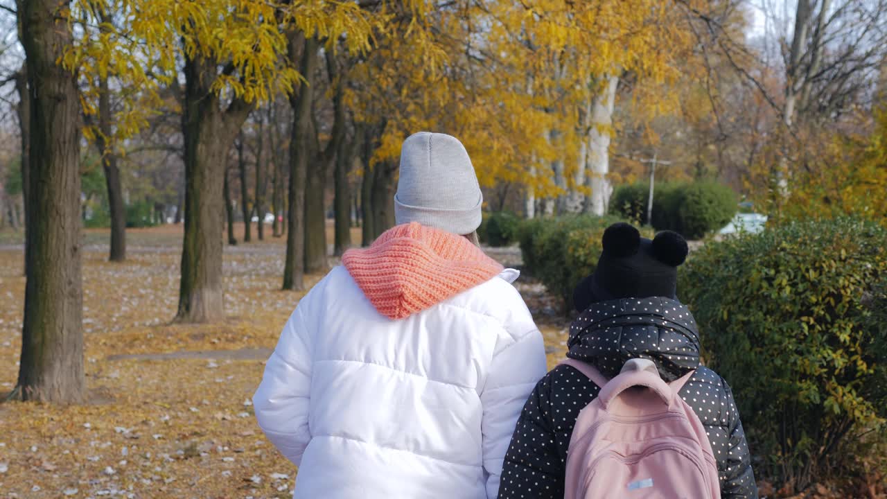 秋天，一个十几岁的女孩和她的妹妹一起从学校走出来。视频下载