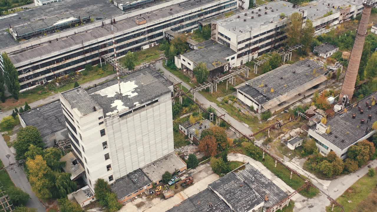 老工厂背景。废弃厂房的工业建筑外观。空荡荡的大片空地上有旧仓库和高楼大厦。鸟瞰图。视频素材