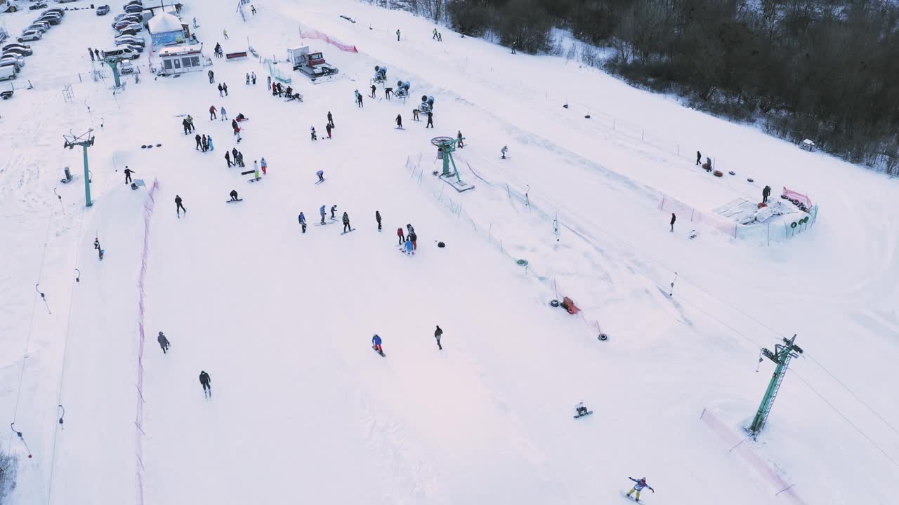 周末，滑雪者和滑雪板运动员在雪坡上滑雪。视频素材