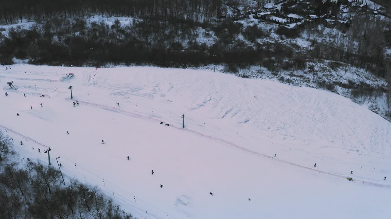 在滑雪场的雪坡上滑雪和滑雪板:无人机拍摄视频素材