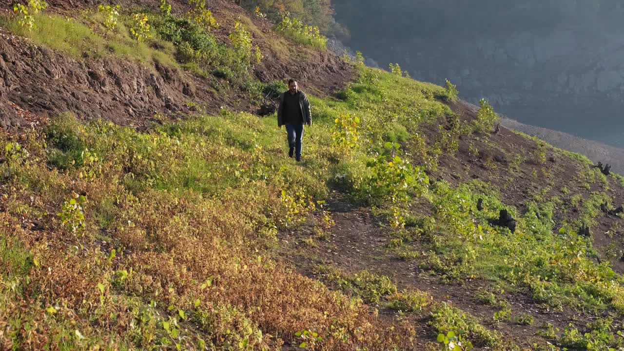 走小路，一个年轻人走在湖边的小路上视频素材