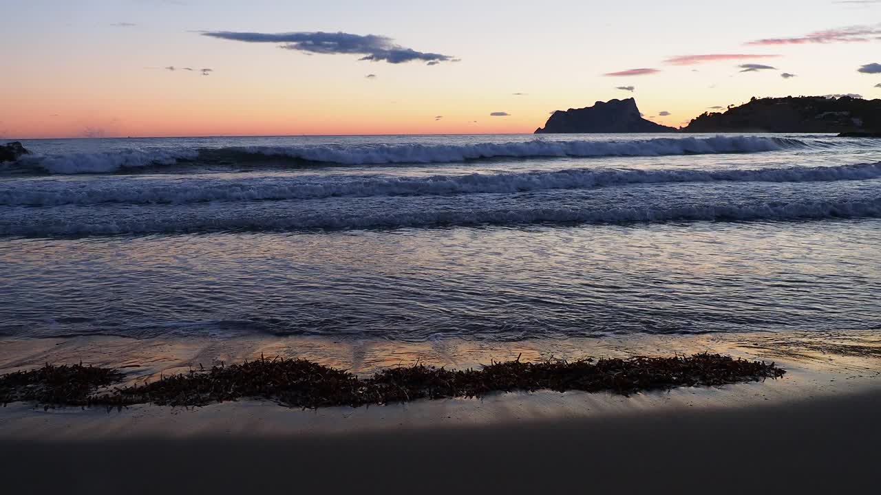 日落时海滩旁边的海岸线景观。视频素材