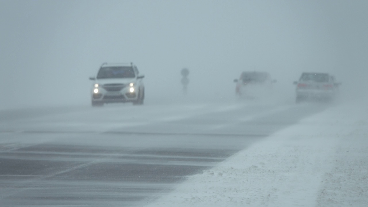 暴风雪中行驶在冬季道路上的汽车视频素材