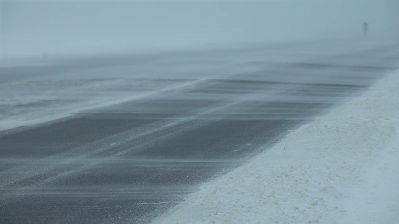 暴风雪中行驶在冬季道路上的汽车视频素材