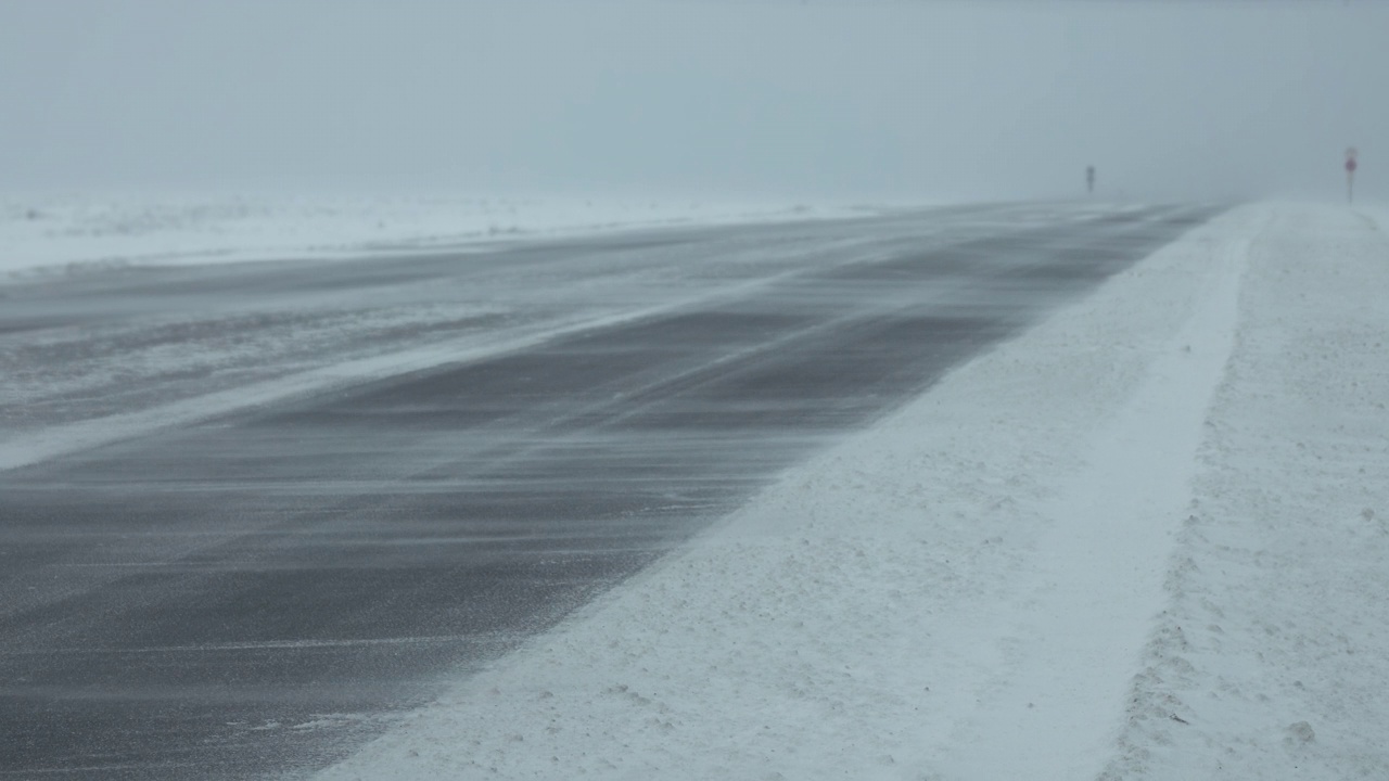 暴风雪中行驶在冬季道路上的汽车视频素材