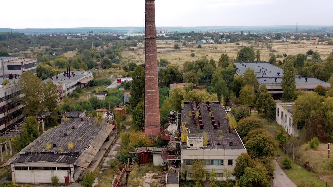 乡下的旧工厂建筑。废弃工厂上的大砖管。大片地区，仓库被毁。鸟瞰图。视频素材