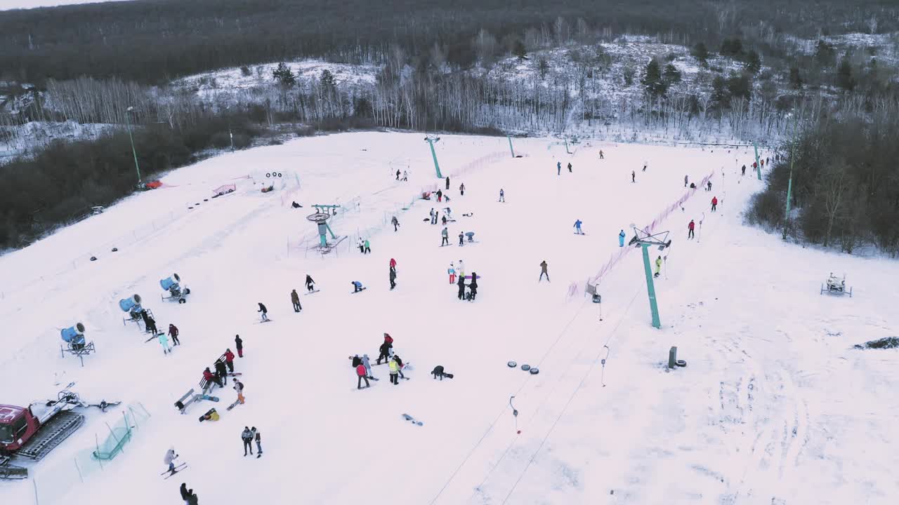 滑雪者和滑雪板运动员用滑雪升降机在雪坡上滑雪。视频素材