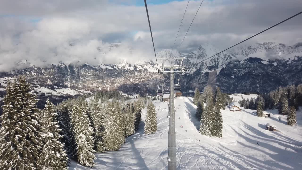 瑞士山区度假胜地Flumserber的滑雪椅升降机视图。白雪覆盖的山脉，阳光灿烂的日子，无法辨认的游客，实时的。视频素材