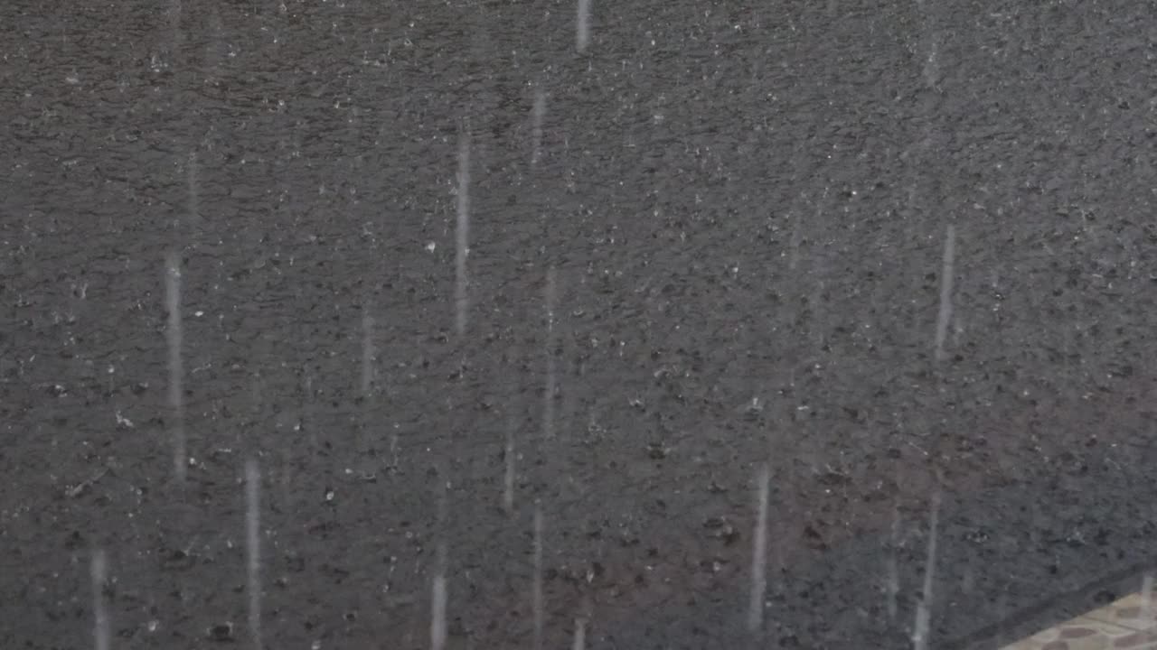 大雨滂沱，雨点在河面上形成不规则的图案视频素材