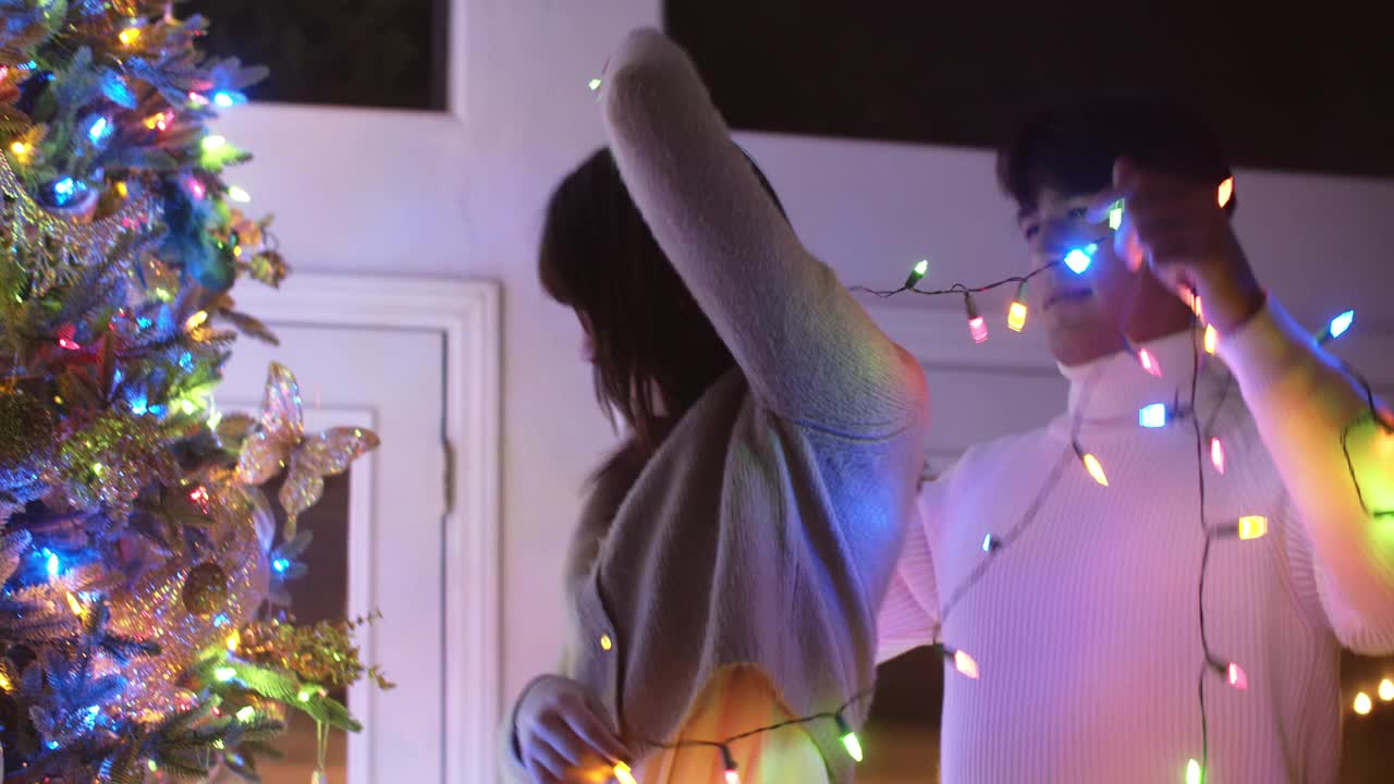 年轻夫妇一起装饰圣诞树视频素材
