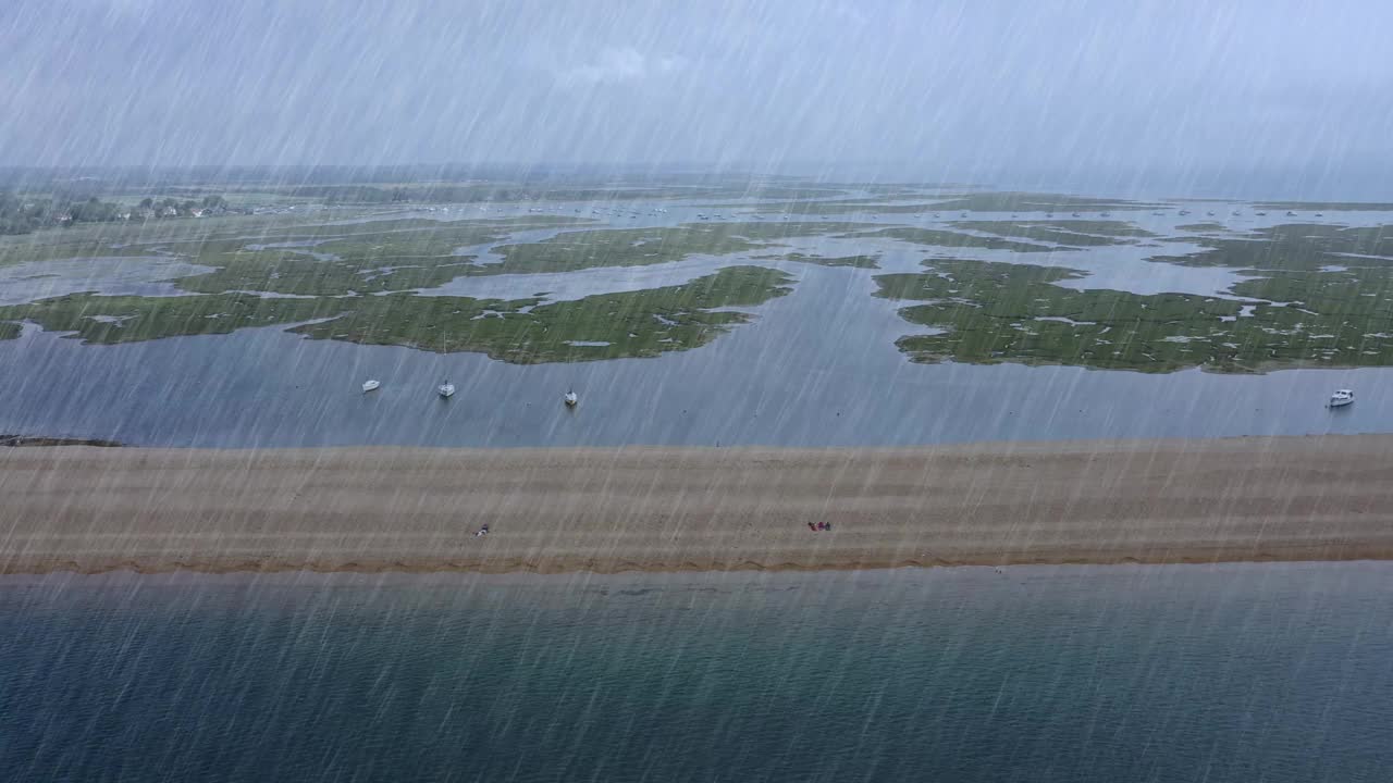 航拍镜头穿越雨在潮湿和寒冷多云的下雨天在伯恩茅斯在南悬崖的海洋视频素材