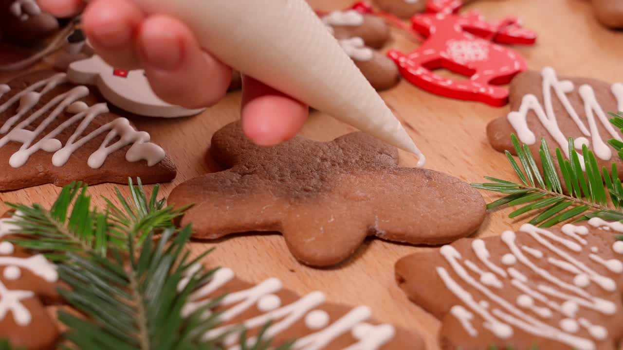 在节日装饰的桌子上画圣诞姜饼，特写视频素材