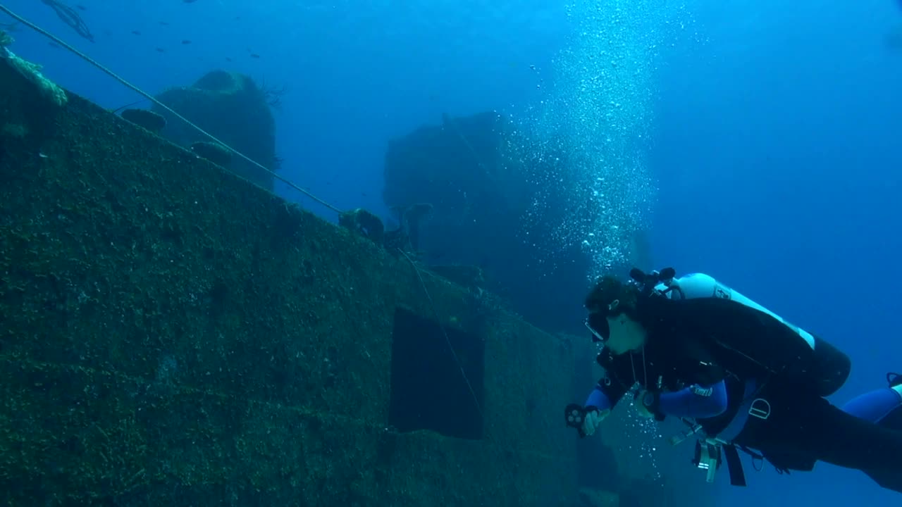 潜水员在沉船旁边漂流视频素材