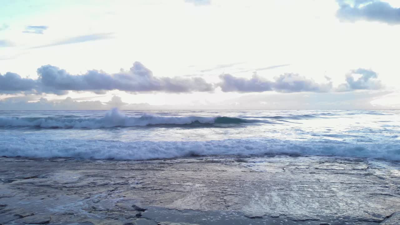 海浪冲击着岩石海滩。暴风雨海洋上戏剧性的多云天空。美丽的自然景观。白色泡沫的海浪到达海岸视频素材