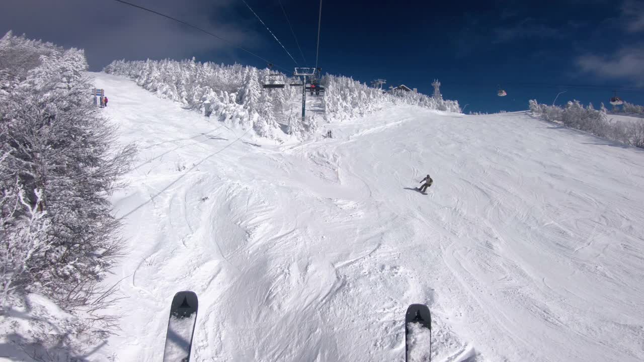 冬季滑雪度假。在滑雪缆车和缆车中用滑雪板进行POV。在雪坡上滑雪，人们在雪天玩耍——冬季运动和户外活动。视频素材