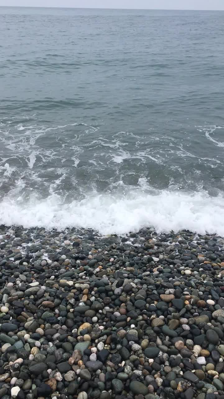 海中。波浪在水中滚过石头和小石子。近距离的水，海浪的声音。视频素材