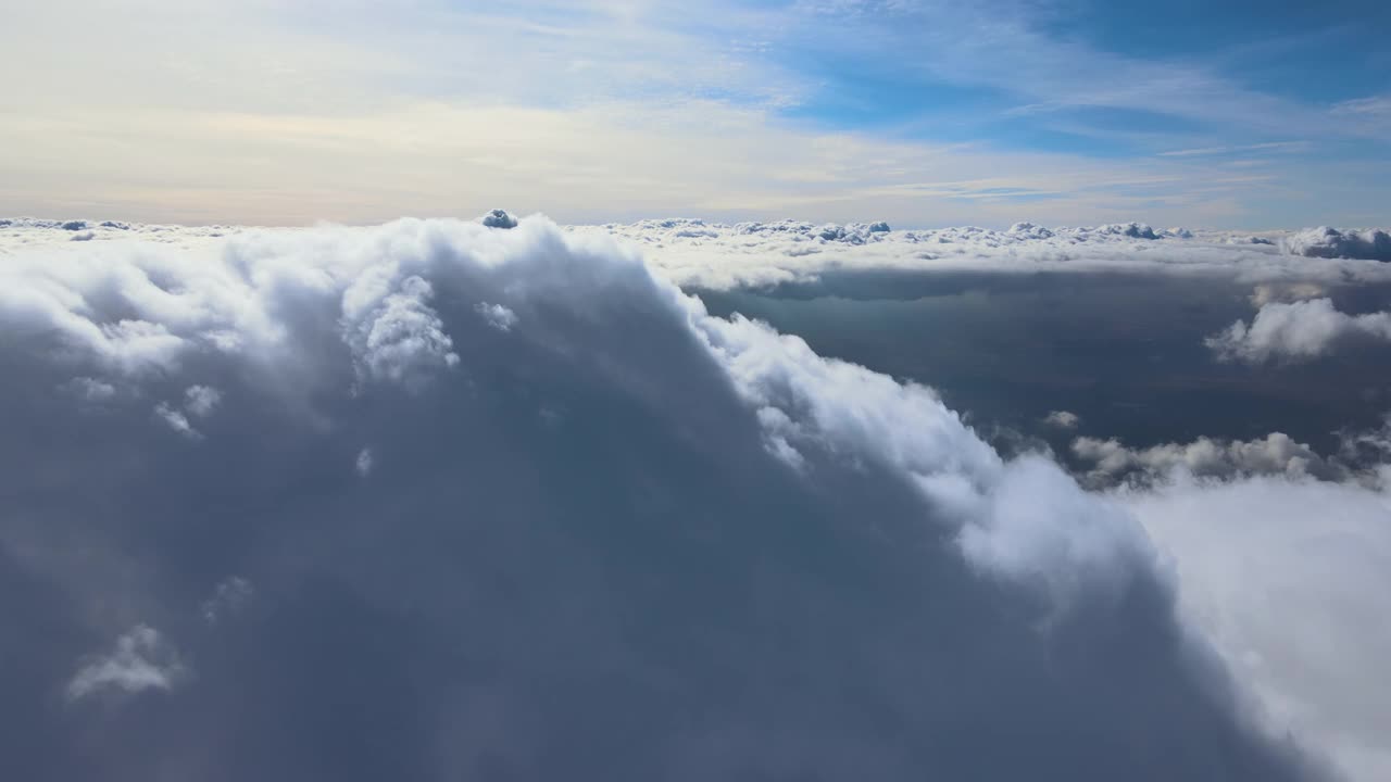 高空从飞机窗口俯瞰覆盖着白色蓬松积云的地面视频素材