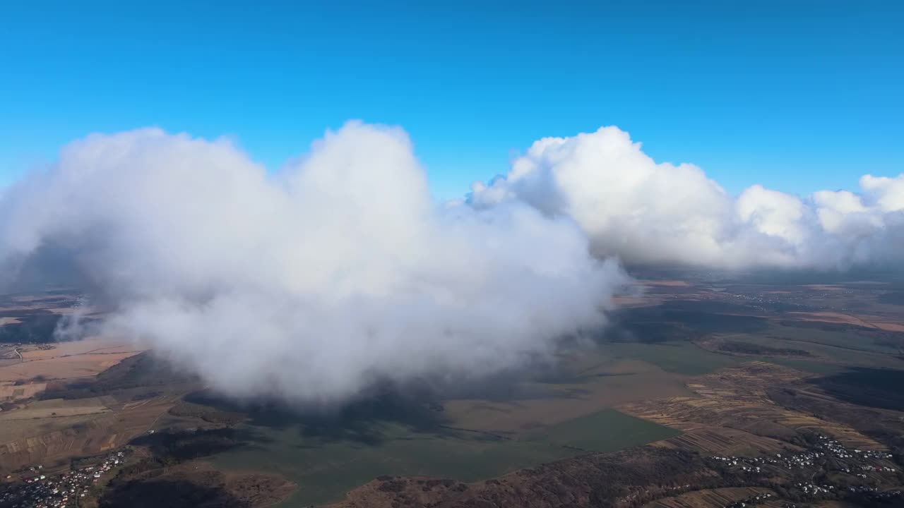 高空从飞机窗口俯瞰覆盖着白色蓬松积云的地面视频素材