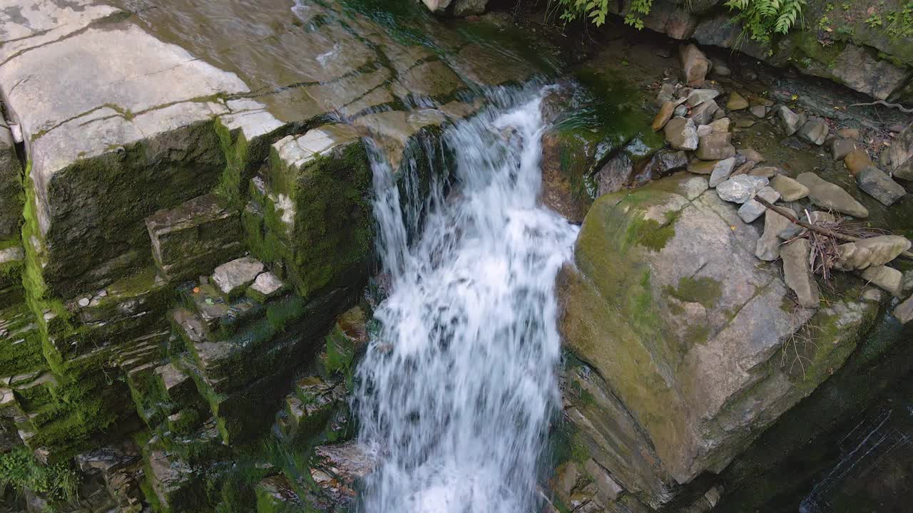 瀑布在山上的河流与白色泡沫水下降下来的岩石形成在夏季森林视频素材