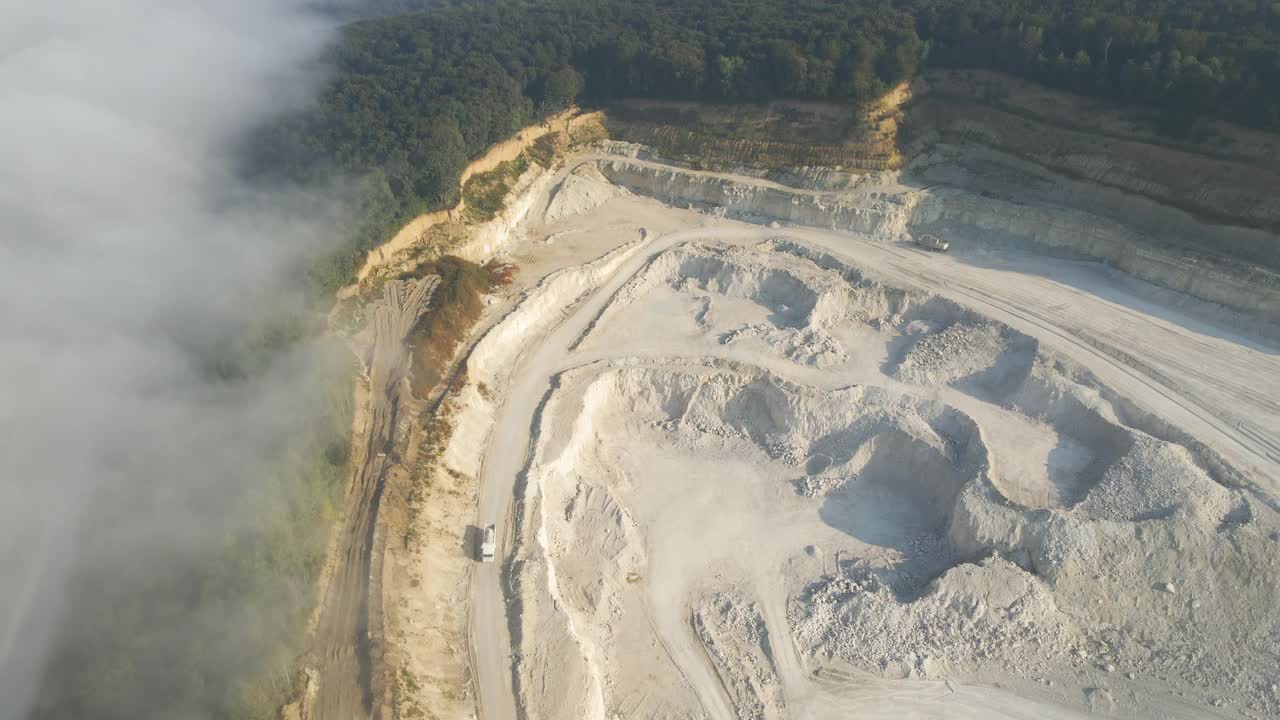 建筑工业用挖掘机和自卸卡车露天开采石灰石材料的鸟瞰图视频素材